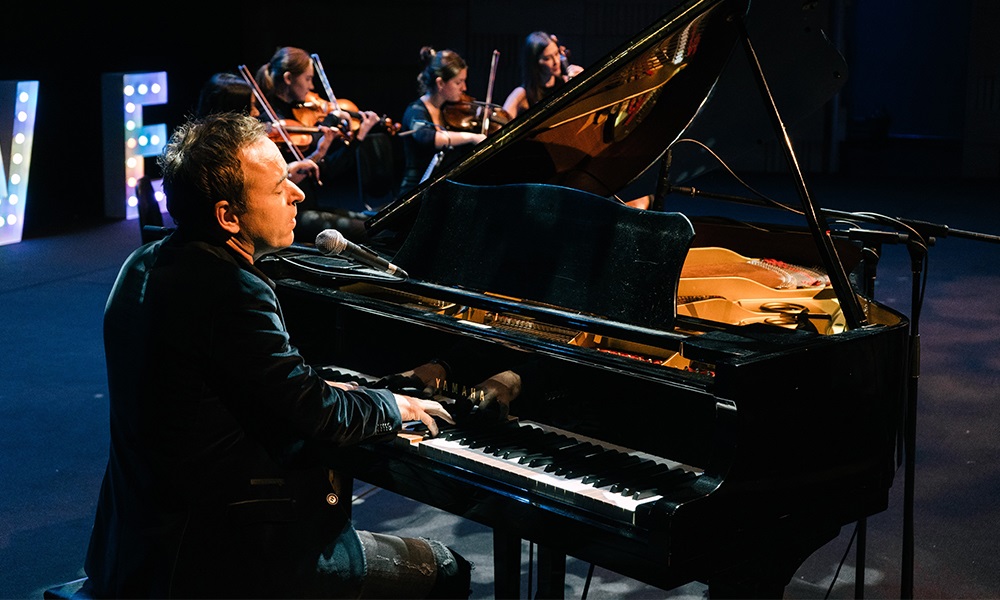 Damien Leith playing piano on stage