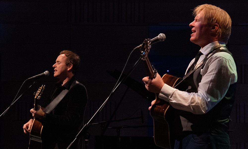 Darren Coggan and Damien Leith on stage playing guitar and singing